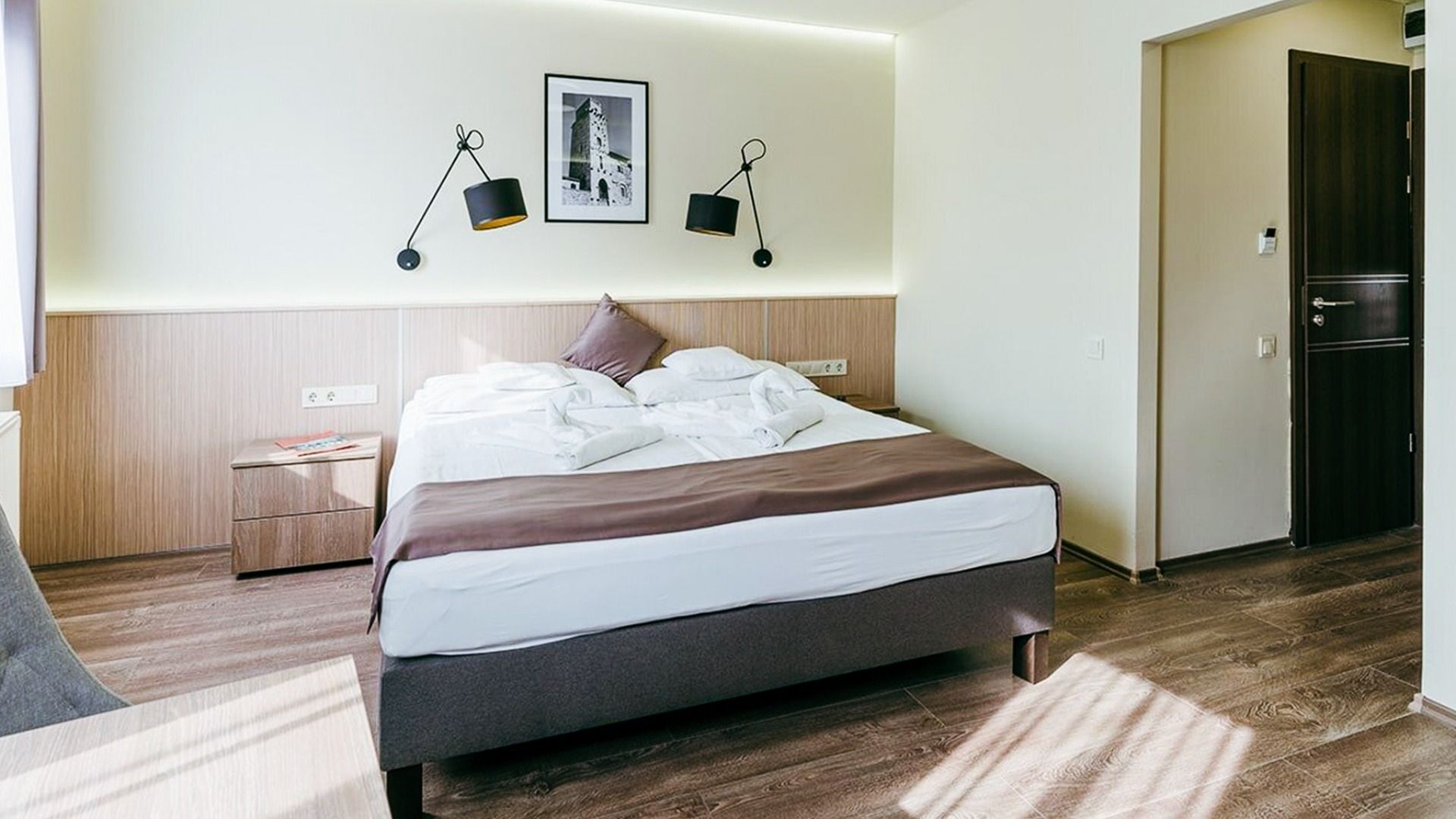 Modern eingerichtetes Hotelzimmer im Hotel Amstel Hattyu Fogado mit gemütlichem Doppelbett und stilvoller Beleuchtung
