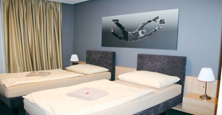 Au&szlig;enansicht des Hotels OtavArena mit moderner Fassade und Sonnenterrasse.