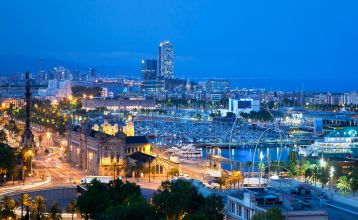 Eingang des CAR Centre d'Alt Rendiment mit wehenden Fahnen der Olympischen Spiele und regionalen Symbolen, daneben geparkte Motorräder.