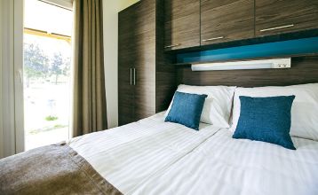 Außenansicht eines modernen Mobilheims mit Holzverkleidung und überdachter Terrasse im Mobile Homes Terme Ptuj.
