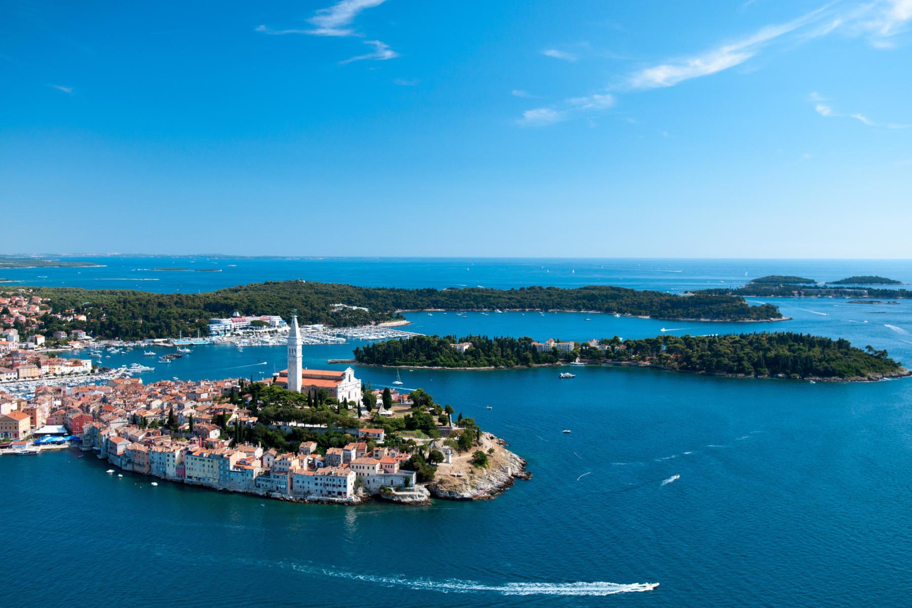 Luftaufnahme einer K&uuml;stenstadt in Kroatien mit Kirche, Glockenturm und umliegenden Inseln im blauen Meer