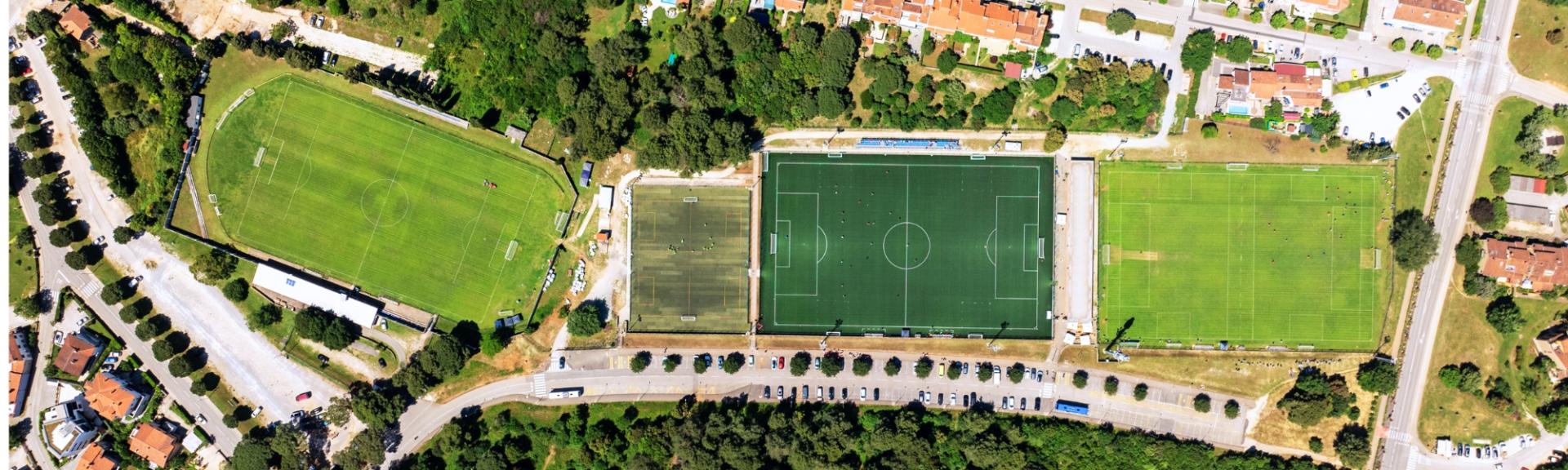 Fu&szlig;ballanlage aus der Vogelperspektive; zwei Rasenpl&auml;tze und ein Kunstrasenplatz; mediterranes Flair