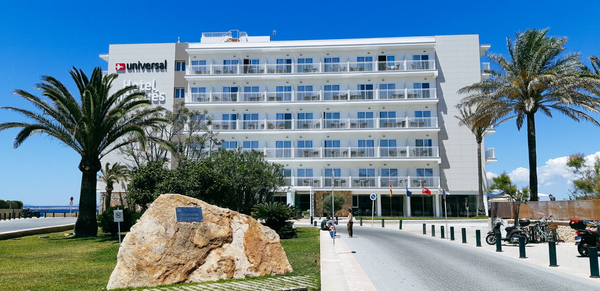 Außenansicht des Hotels Marques mit moderner weißer Fassade, Palmen und gepflegter Gartenanlage.