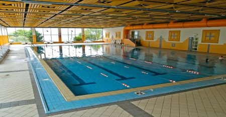 Au&szlig;enansicht des Hotels Aquapark Zusterna mit rosa Fassade, Balkonen und der slowenischen Flagge.