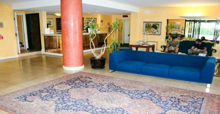 Au&szlig;enansicht des Hotels Villa Maria mit Balkonen, gepflegtem Garten und mehreren Nationalflaggen vor dem Geb&auml;ude
