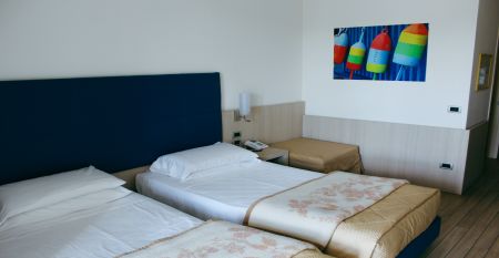 Au&szlig;enansicht des Hotel Pra Delle Torri mit viel Gr&uuml;n und zwei Stockwerken mit Balkonen darunter der Eingang und das Restaurant