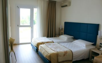 Außenansicht des Hotel Pra Delle Torri mit viel Grün und zwei Stockwerken mit Balkonen darunter der Eingang und das Restaurant