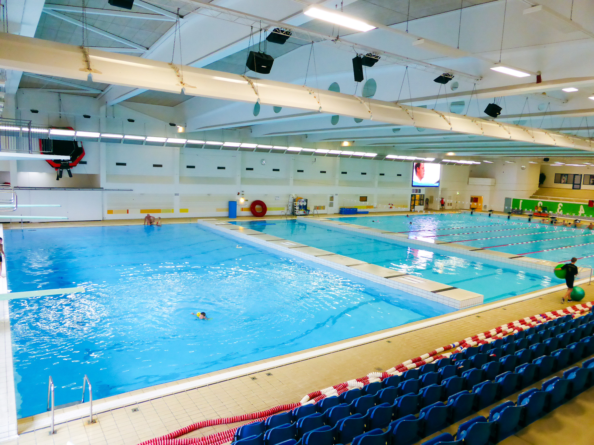 Au&szlig;enpool mit mehreren Schwimmbahnen, bunten Leinen und Meerblick im Hintergrund.